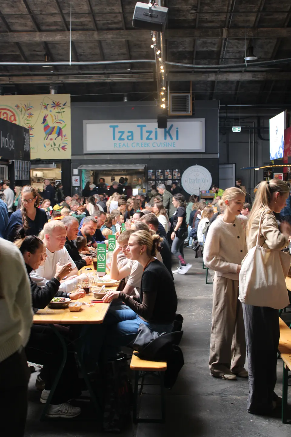 Gæster ved langborde i Garagen foran Tza Tzi Ki